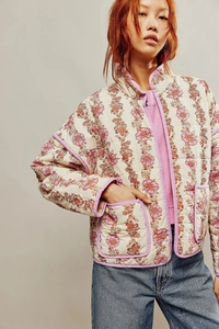Close-up of quilted floral jacket featuring purple piping and vintage pattern detail