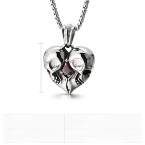 Macro shot of punk heart skull pendant with red pear-cut zircon and stainless steel chain