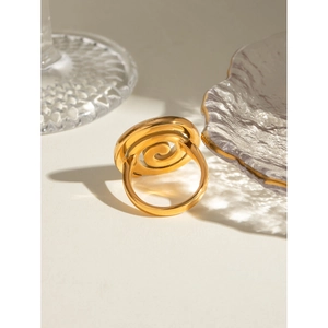 Detailed view of an 18k gold-plated stainless steel spiral ring on a white surface