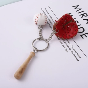 Detail of baseball keychain with a mini bat, glove, and ball on a white paper background