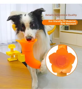 Detail of durable orange flower dog ball launcher fixed to table with yellow G-clamp