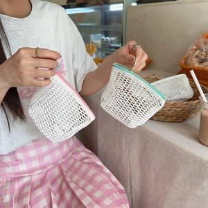 Detailopname van mesh mini portemonnee met gekleurde ritsen in de hand