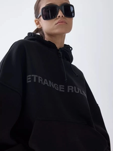 Detail of black oversized hoodie with ETRANGE RULE print and stylish square sunglasses