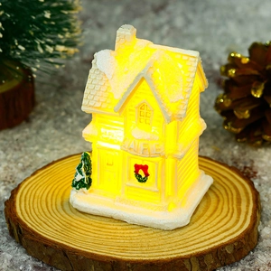 Detailed view of glowing resin Christmas cafe house model with warm light and festive pine