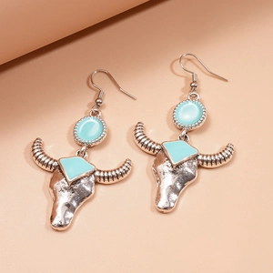 Detail of vintage silver bull head earrings with turquoise blue stone and geometric shadow