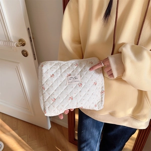 Floral quilted pouch held by a model in a cozy, bright home setting for daily storage
