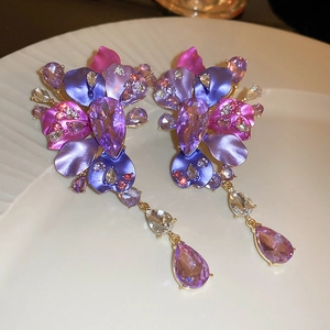 Detail of luxury purple floral earrings featuring crystal drops and vibrant petal layers