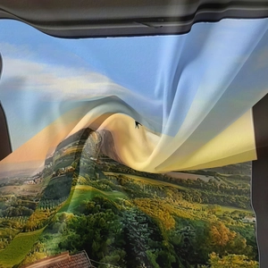 Detail of bohemian tapestry featuring a vibrant scenic landscape print with hills and sky