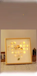 Detail of DIY seashell night light kit with wooden frame, starfish, and warm LED lights