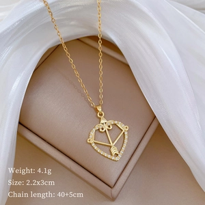 Macro shot of gold cupid heart pendant with size details on beige jewelry tray
