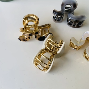 Selection of elegant wavy claw clips in gray, tortoiseshell and cream tones on white base