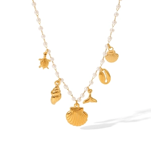 Detail of a pearl necklace with golden sea charms like turtles and whale tails