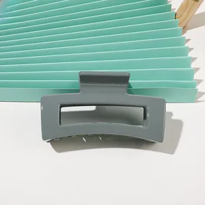Detailed view of a grey rectangular claw clip with a glossy finish and hollow design