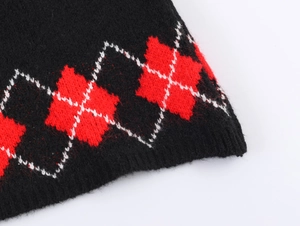 Detail of black knit fabric with classic red and white argyle jacquard pattern