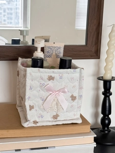 Quilted fabric organizer with cute bear prints used for storing cosmetics on a desk