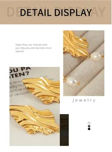 Détail de boucles d'oreilles feuille dorée texturée avec élégante perle blanche