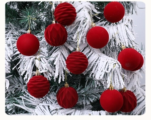 Detail of 6cm red Christmas balls with various textures hanging on snowy tree branches