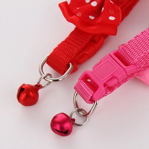 Close-up of pet collar with nylon webbing, plastic buckle, and shiny metal bell detail