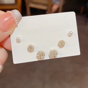 Detail of 6-piece earring set featuring sparkling cubic zirconia flowers and white pearls