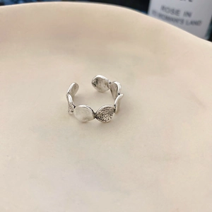 Detail eines Vintage Silberrings mit unregelmäßiger Hammerschlagstruktur auf Keramik