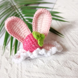 Detailed view of hand-knitted hair clip featuring pink rabbit ears and strawberry design