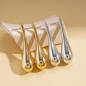 Polierte metallische Tropfenohrstecker in Gold und Silber auf einem Display