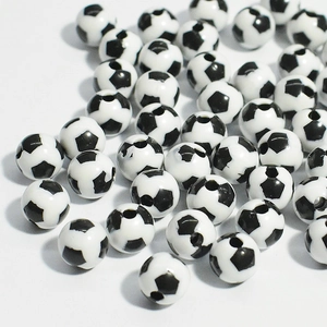Gros plan de perles de football en acrylique noir et blanc avec trou pour bijoux DIY