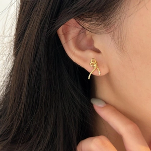 Elegant gold bow earrings with micro zircons worn by model for a minimalist style