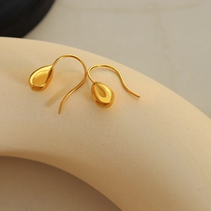 Elegant gold teardrop earrings with mirror polish finish on a minimalist display