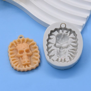 Detailed macro view of a skull silicone mold and orange resin pendant with hole