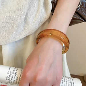 Retro amber acrylic bangle with tortoiseshell texture on wrist for a vintage aesthetic style