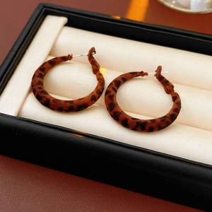 Vue rapprochée de boucles d'oreilles rondes floquées léopard dans un coffret cadeau