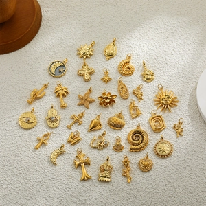 DIY jewelry set with 18K gold-plated charms like sun, moon, and cross on white texture