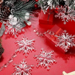 Clear acrylic snowflake ornaments and icicle decorations on festive red background
