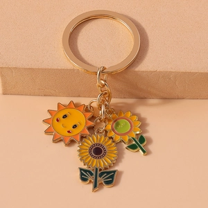 Detailed view of metal sunflower and bee charms with vibrant enamel finish on golden keychain