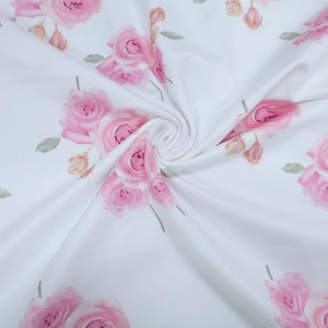 Close-up of elegant white fabric featuring pink rose floral print and fine texture