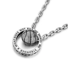 Detail of silver necklace pendant featuring a basketball and engraved inspirational quote