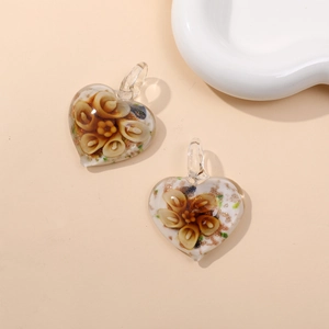 Macro view of heart-shaped glass pendants with gold glitter and floral inner patterns