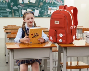 Detail of red large capacity school backpack with side buckles in a classroom setting