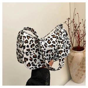 Detailed close-up of a leopard print baguette bag featuring black, white and brown patterns