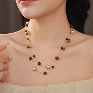 Detail einer Vintage-Halskette mit Tigerauge-Perlen und Perlen auf einer Goldkette