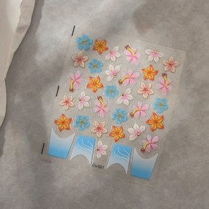 Macro shot of 3D hibiscus and floral nail stickers in blue and orange colors Co-521