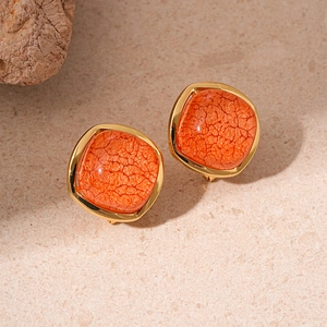 Detail of square orange resin earrings with vintage cracked texture and gold metal base