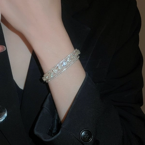 Close-up of triple-layer silver flower bracelet with sparkling crystals on a wrist