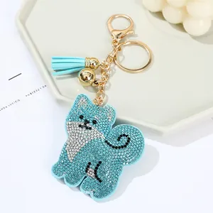 Detail of blue rhinestone Shiba Inu keychain with golden bell and silk tassel