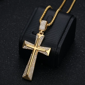 Pendentif croix en acier doré style Hip Hop avec cristaux étincelants sur fond noir mat