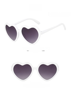 Detail view of heart-shaped kids sunglasses with white frames and grey lenses