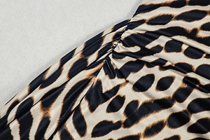 Macro shot of leopard print dress fabric featuring gathered detail and pleated texture