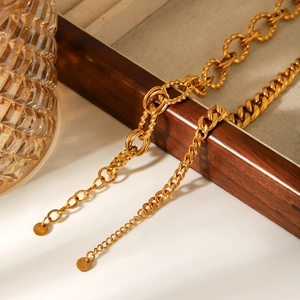 Dettaglio di bracciali a catena cubana e a fune dorati su una scatola di legno