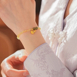 Detailansicht eines Armbands mit gelben Zitrinperlen und goldenem Kürbis-Anhänger